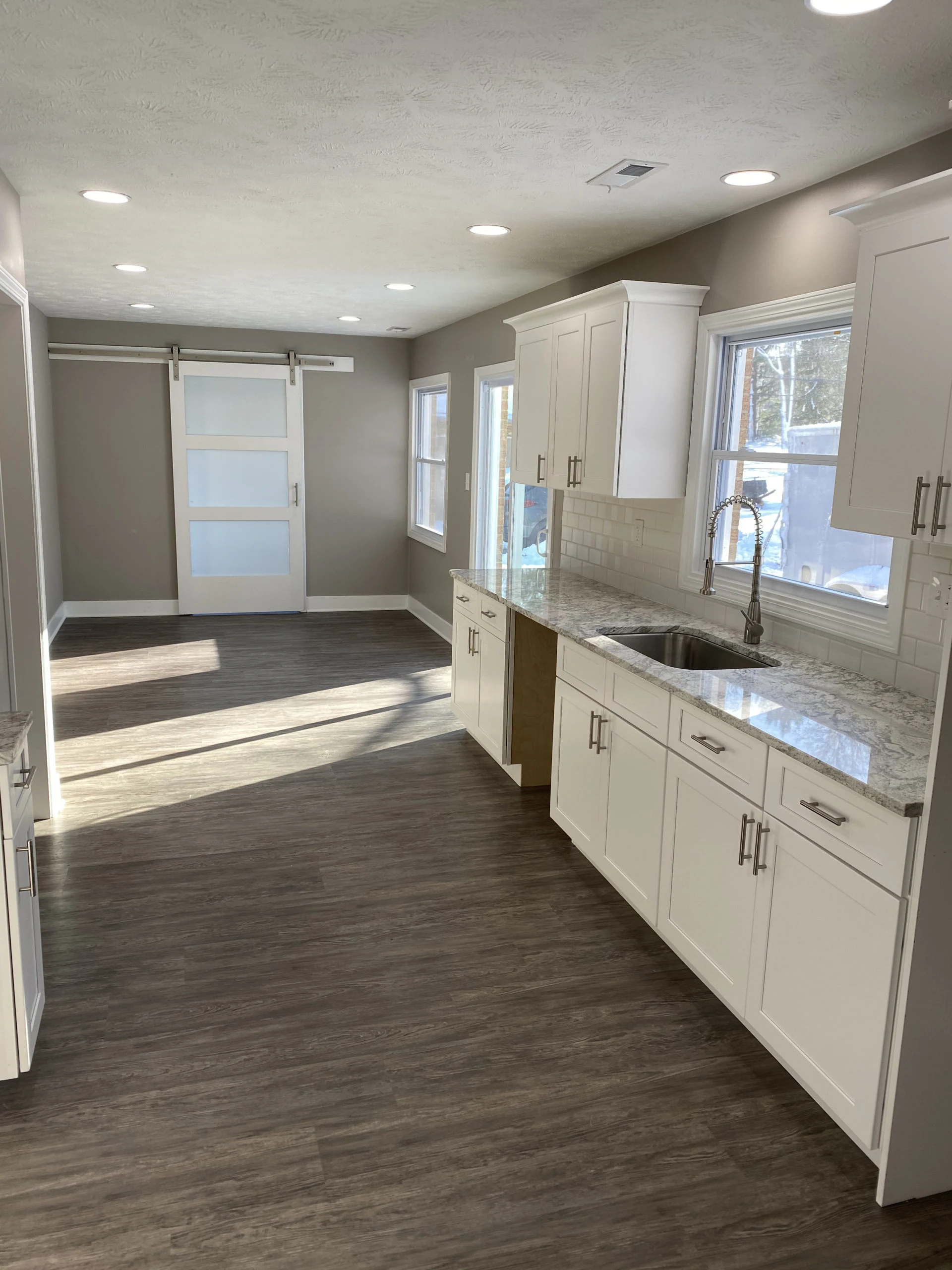 Bright finished kitchen with white cabinets and wood accents